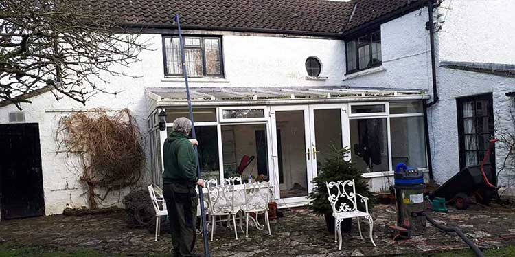 Pixies employee cleaning gutters